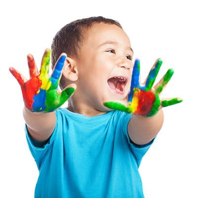 A happy Educare Academy child with painted hands